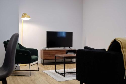 a living room with two chairs and a flat screen tv at 7 Cannon Street in Preston