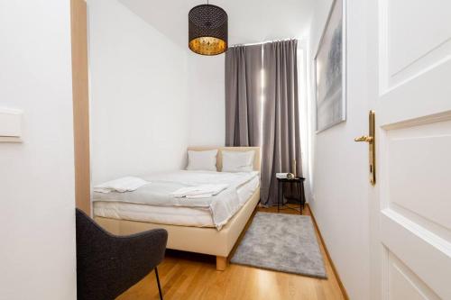 - une petite chambre avec un lit et une chaise dans l'établissement OrestaLiving- 3BR On the Daube Canal/Friedensbrücke, à Vienne