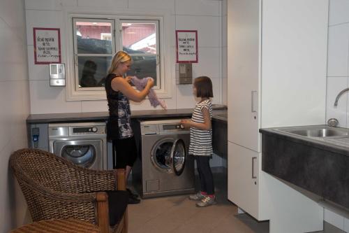 a woman and a little girl in a laundry room at Sølvgarden Camping in Rysstad