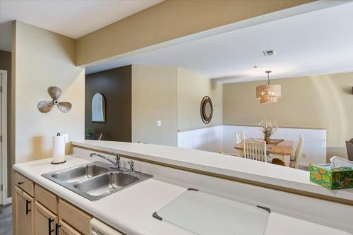 a kitchen with a sink and a dining room at Condo at Parkview Bay - Your Lakefront Oasis in Osage Beach