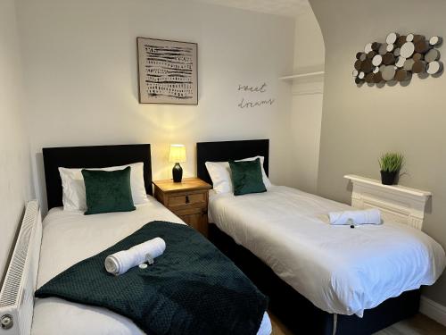 dwa łóżka siedzące obok siebie w sypialni w obiekcie Luxury Stays w mieście Birkenhead