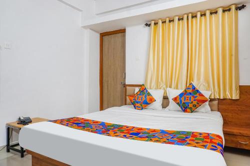 a bedroom with a bed and a window at FabHotel Lake View in Pune