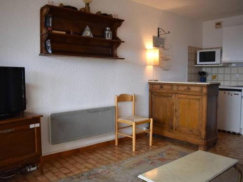 une cuisine avec une table et une chaise dans une pièce dans l'établissement À 2 min des pistes, appart 2 pièces cabine avec loggia vitrée et cuisine équipée - FR-1-580-36, à Font-Romeu-Odeillo-Via