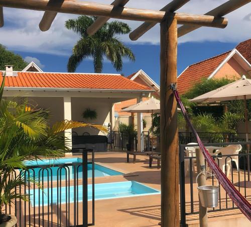 ein Pool mit Sonnenschirmen und ein Resort in der Unterkunft Chalé Apart Hotel in Bonito