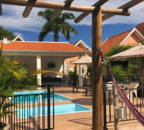 - une piscine avec des parasols et un complexe dans l'établissement Chalé Apart Hotel, à Bonito