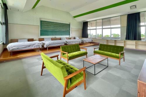 ein Wartezimmer mit grünen Stühlen und einer Couch in der Unterkunft LivingAnywhere Commonsうるま 4bed room - Vacation STAY 65070v in Uruma
