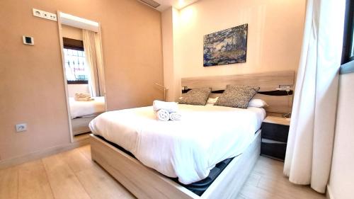 1 dormitorio con 1 cama grande y espejo en Apartamentos Vacacionales Joctis, Bajo A, en Fuengirola