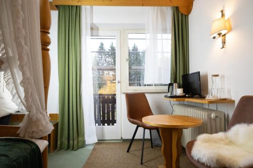 a room with a desk and a window with a table at Hotel zum See, Titisee in Titisee-Neustadt