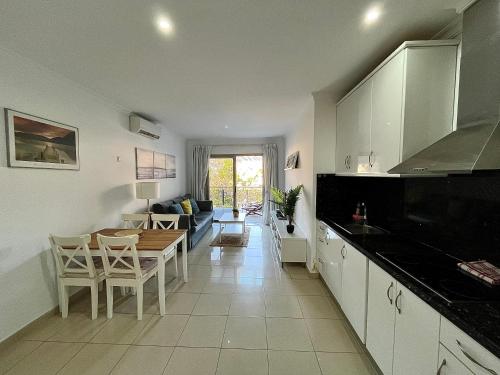 莫甘海灘的住宿－COSTA AZUL APARTMENTS - 2B，厨房以及带桌椅的起居室。