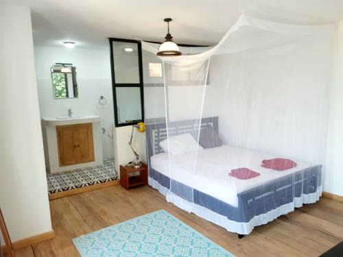 een kleine slaapkamer met een bed en een badkamer bij Mon paradis in Saint-Louis