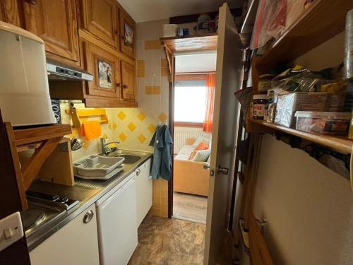 une petite cuisine avec un évier et un réfrigérateur dans l'établissement Appartement 6 personnes au pied des pistes, à La Plagne Tarentaise