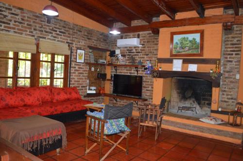 a living room with a red couch and a fireplace at Casa con piscina y parque in Garupá