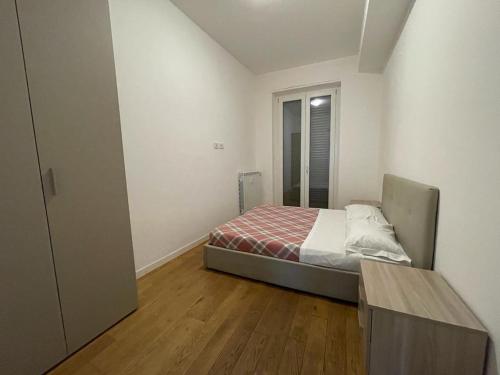 a small bedroom with a bed and a wooden floor at IMHOME - Porta Vittoria in Milan