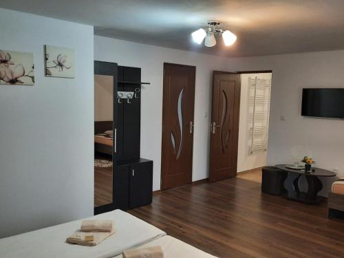ein Wohnzimmer mit Holzböden und ein Zimmer mit einem Tisch in der Unterkunft Casa Truța in Topliţa