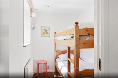 a bedroom with a bunk bed with a red stool at Orehus - Country side cottage with garden in Sjöbo