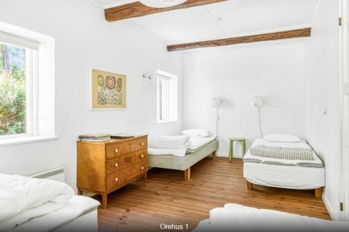 1 dormitorio blanco con 2 camas y vestidor en Orehus - Country side cottage with garden en Sjöbo