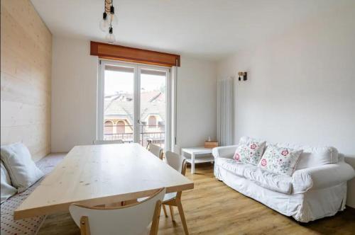 - un salon avec une table et un canapé dans l'établissement WoodenKey Asiago moderno bicamere in centro, à Asiago