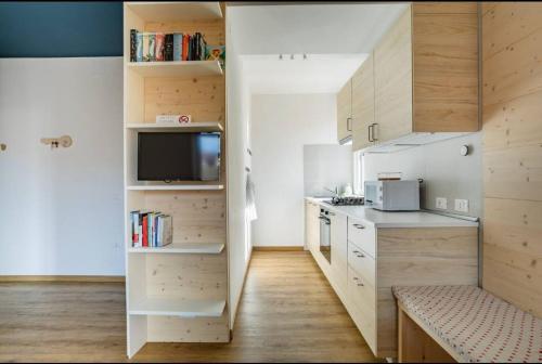 una piccola cucina con armadi bianchi e una TV di WoodenKey Asiago moderno bicamere in centro ad Asiago