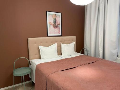 a bedroom with a bed with a pink comforter at Light modern Pallo apartment by the lake Saimaa in Lappeenranta