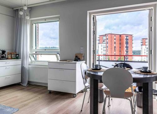 cocina con mesa, sillas y ventana en Light modern Pallo apartment by the lake Saimaa, en Lappeenranta