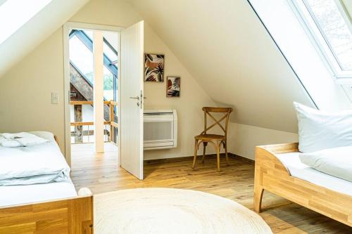 Cette chambre mansardée comprend 2 lits et une fenêtre. dans l'établissement Ferienwohnung "Stellmacherei", à Versmold