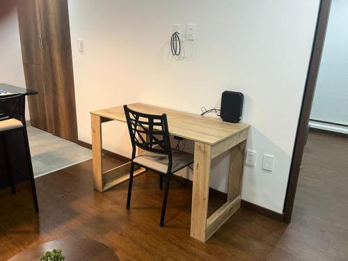 einen Holzschreibtisch mit einem Stuhl und einem Lautsprecher darauf in der Unterkunft Apartamento Nuevo en San Miguel - La Paz in La Paz
