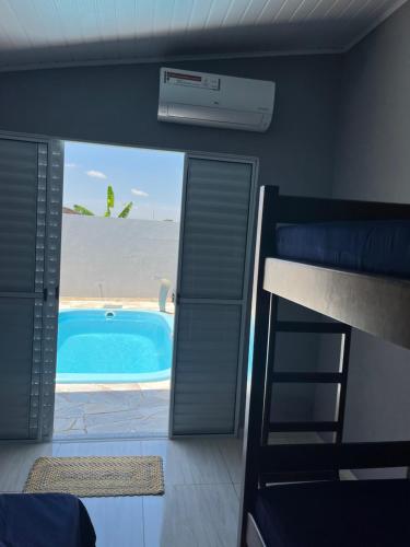 a room with a swimming pool and a bunk bed at Casa do Bruno in Olímpia