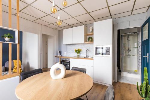 une cuisine et une salle à manger avec une table en bois dans l'établissement Appartement cozy en face de la gare - Saint-Brieuc, à Saint-Brieuc