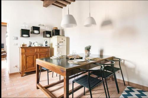 a kitchen with a table and chairs and a refrigerator at Vuotopieno Casa Blue Maremma in Orbetello