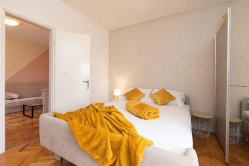 a bedroom with a bed with a yellow blanket on it at Apartment in Vrbnik/Insel Krk 13613 in Vrbnik