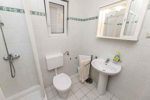a white bathroom with a toilet and a sink at Apartment in Vrbnik/Insel Krk 13603 in Vrbnik