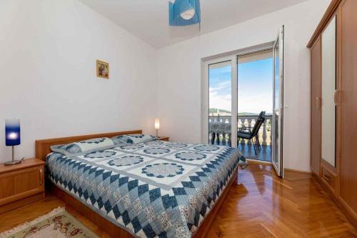 a bedroom with a bed and a balcony with a view at Apartment in Vrbnik/Insel Krk 13603 in Vrbnik