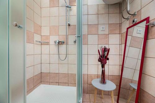 a bathroom with a shower with a vase of flowers on a table at Apartment in Vrbnik/Insel Krk 13610 in Vrbnik