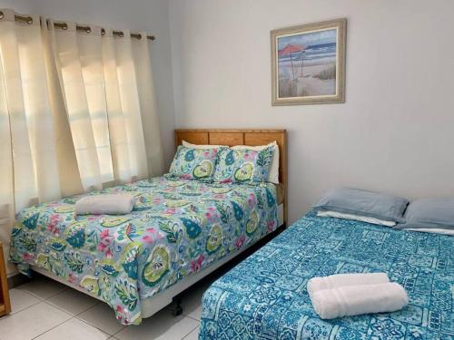 a bedroom with two beds in a room at SUITE 1, Blue Pavilion - Beach, Airport Taxi, Concierge, Island Retro Chic in West Bay