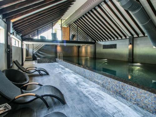 a swimming pool with chairs in a building at Corn House in Plaish
