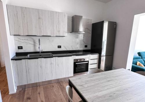 eine Küche mit einer Spüle, einem Kühlschrank und einem Tisch in der Unterkunft Casa del Sol Luxury Estate Puglia in Leporano Marina