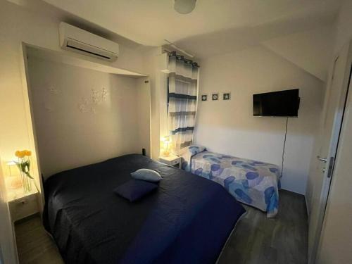 Habitación pequeña con 2 camas y TV. en Seafront, en San Benedetto del Tronto