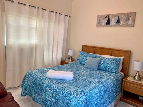 sypialnia z łóżkiem z niebieską kołdrą w obiekcie SUITE 4, Blue Pavilion - Beach, Airport Taxi, Concierge, Island Retro Chic w mieście West Bay