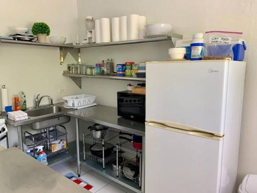een keuken met een witte koelkast en een wastafel bij SUITE 4, Blue Pavilion - Beach, Airport Taxi, Concierge, Island Retro Chic in West Bay