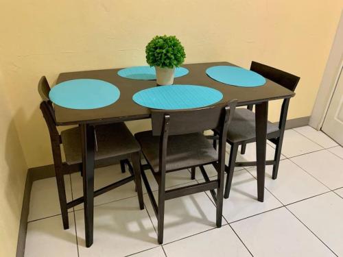 a table with four chairs and a potted plant on it at SUITE 2A, BLUE PAVILION - Steps to BEACH in West Bay
