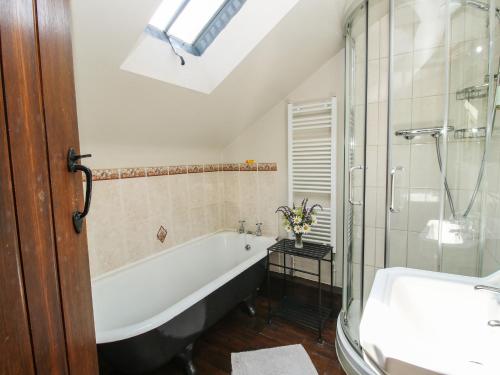 a bathroom with a tub and a shower and a sink at Turnip House in Plaish