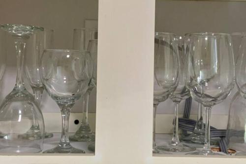 a group of wine glasses sitting on a shelf at SUITE 2A, BLUE PAVILION - Steps to BEACH in West Bay