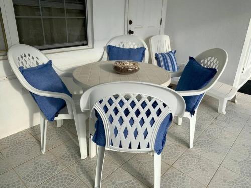 four chairs and a table with a blue and white dining room at SUITE 2A, BLUE PAVILION - Steps to BEACH in West Bay