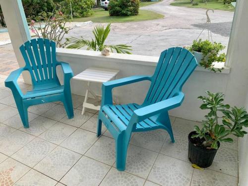two blue chairs and a table on a porch at SUITE 2A, BLUE PAVILION - Steps to BEACH in West Bay
