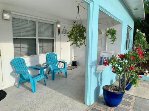two blue chairs and a table on a patio at SUITE 2A, BLUE PAVILION - Steps to BEACH in West Bay