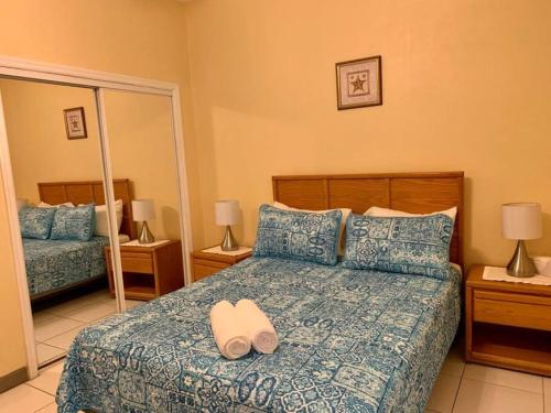 1 dormitorio con 1 cama con sombrero en SUITE 2B, Blue Pavilion - Private Executive Bedroom in Shared Suite - Beach, Airport Taxi, Concierge, Island Retro Chic, en West Bay