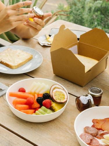 a table topped with plates of food and a box of crackers at 7Pines Resort Ibiza, part of Destination by Hyatt in San Jose