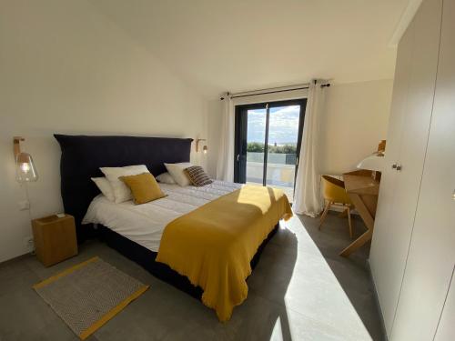 une chambre avec un lit avec une couverture jaune dessus dans l'établissement Villa Arazu, 10 personnes, piscine chauffée, vue mer, 15 minutes à pieds plage, à Cirendinu