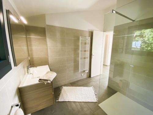 une salle de bain avec un lavabo et une douche dans l'établissement Villa Arazu, 10 personnes, piscine chauffée, vue mer, 15 minutes à pieds plage, à Cirendinu