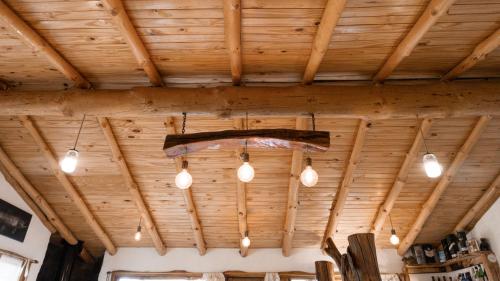 a group of lights hanging from a wooden ceiling at Cabañas El Arriero Lodge in Manzano Amargo